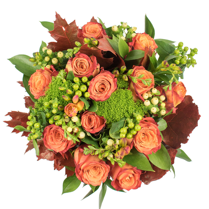 Presented in a circular, top-down composition on a crisp white background, this autumn-inspired bouquet reads like a warm patchwork of seasonal textures. Dominated by fully opened roses that graduate from warm peach at their centres to coral and deep orange towards the petal margins, the blooms display a soft ombré that evokes falling leaves. Interspersed throughout are small clusters of Hypericum berries-some in a striking lime-green that almost glows, others in a soft creamy-yellow-whose smooth, round forms add a lively, tactile contrast to the velvety roses. Compact tufts of Green Trick dianthus offer a dense, moss-like texture; their bright, grassy green provides a textural anchor and a fresh, modern twist against the more traditional roses. Scattered large, lobed leaves in rich burgundy and burnt orange bring an autumnal weight and a suggestion of crisp, rustling foliage, while various glossy green leaves fill out the composition, giving breadth and a sense of abundance. The light is soft and diffuse, casting gentle highlights on the petals and berries that enhance the bouquet's three-dimensional depth while maintaining an intimate, cozy mood. There's an understated fragrance of roses tempered by green, earthy notes that conjure images of the local shoreline and Docklands walks. Suitable as a Thanksgiving focal point, a thoughtful seasonal gift, or to warm a Shadwell home, this arrangement would travel well for delivery around Shadwell, Wapping and Limehouse when a touch of autumn warmth is needed.